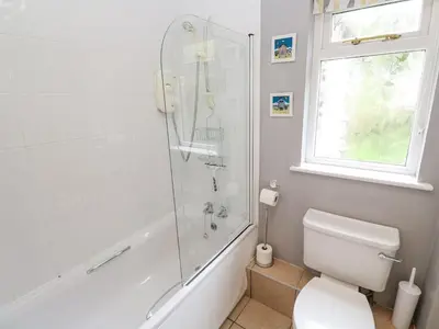 a bathroom with a shower and a toilet and a window at Chy Lowena in Falmouth
