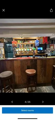 a bar with two stools sitting at a counter at Kings head in Chacewater