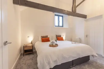 a bedroom with a large white bed with orange pillows at Manor in Bude