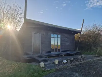 a small house with the sun shining through the windows at Manor in Bude