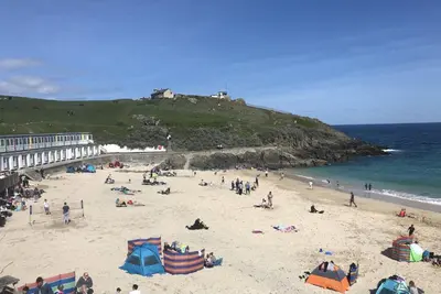 a group of people on a beach near the ocean at Morning Cottage in St Ives