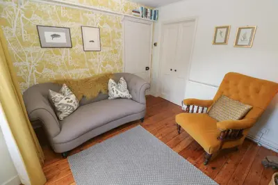 a living room with a couch and a chair at Apple Tree Cottage in Helston