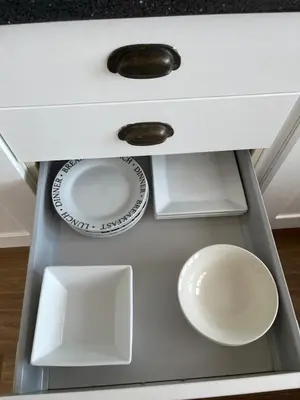 a white cabinet with plates and bowls in it at Hellfire corner in Redruth