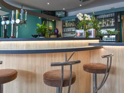 a bar with two stools at a counter in a restaurant at Dreckly in Falmouth