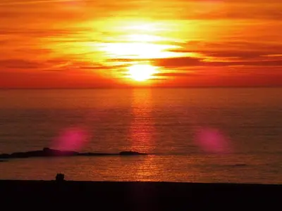 a sunset on the beach with the sun setting at Ocean Breezes in St Ives