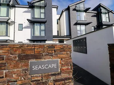 a house with a sign that reads escape at Fistral Tide in Newquay