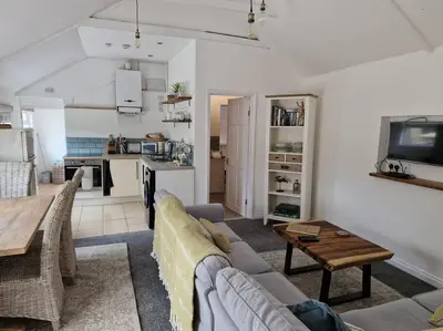a living room with a couch and a table at Trenant Cottage in Fowey
