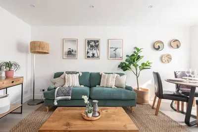 a living room with a green couch and a table at Stylish apartment with parking - Flat 2 Mill House in Penryn