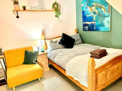 a bedroom with a bed and a yellow chair at Seaview Surf Studios in Newquay