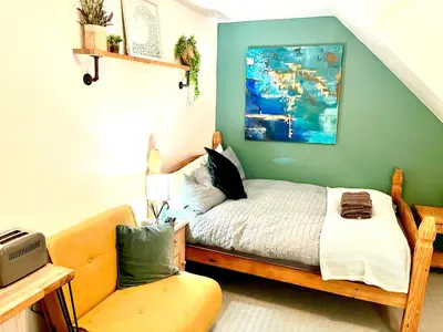 a bedroom with a bed and a chair in it at Seaview Surf Studios in Newquay