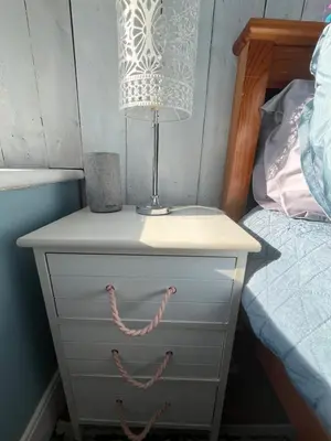 a nightstand with a lamp on it next to a bed at Seaview Surf Studios in Newquay