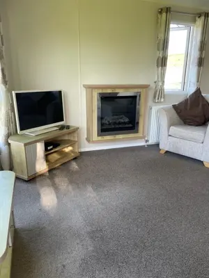 a living room with a tv and a fireplace at Rubys Retreat - 6 Berth Caravan in Newquay, Cornwall in Newquay