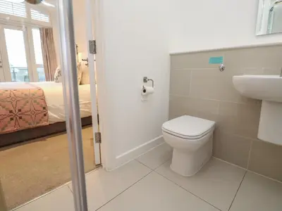 a bathroom with a toilet and a sink and a bed at Una, Lodge 73 in St Ives