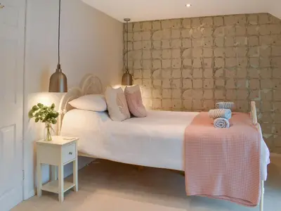 a bedroom with a large white bed and a table at Crew Quarters in Fowey