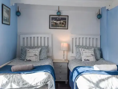 two beds sitting next to each other in a bedroom at Harbour Studio in Polperro