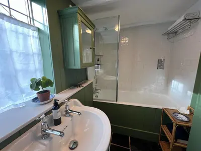 a bathroom with a sink and a shower and a tub at Rosebank Cottage in Boscastle