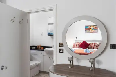 a bathroom with a mirror and a sink at 3 The Elms in St Ives