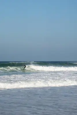 a person riding a wave on a surfboard in the ocean at Modern Apartment Sea Views Private Parking in Newquay