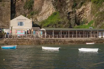 three boats in the water in front of a building at Cosy Apartment Parking Central Newquay in Newquay