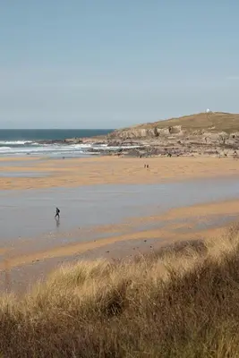 a person walking in the water on a beach at Family Home in Newquay Parking 3 mins to Beach in Newquay