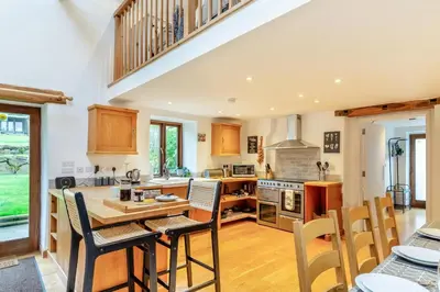 a large kitchen with a wooden table and chairs at 4 Bed in Torpoint oc-m30122 in Downderry