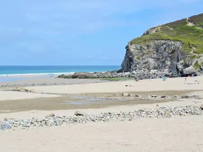 a beach with rocks and people on the beach at Swallows in Mount Hawke
