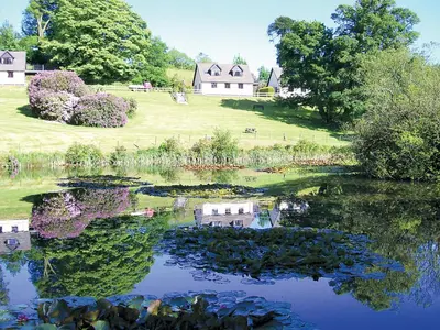 a reflection of a house in the water of a lake at Rosecraddoc Manor - Riverbank in Saint Cleer