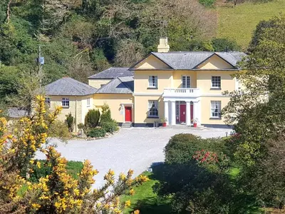 an aerial view of a large yellow house with a driveway at Rosecraddoc Manor - Riverbank in Saint Cleer
