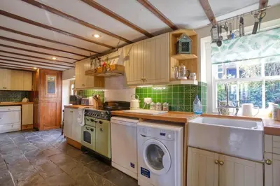 a kitchen with a washing machine and a sink at Historic Chapel Great Facilities nr Beaches in Saint Ewe