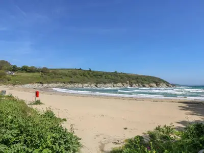 a beach with a red object in the sand at Dowager Cottage in Penryn