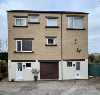 a large brick house with a garage at The Shack 1 bedroom apartment in Newquay