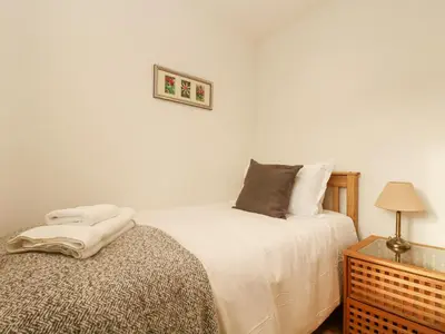 a bedroom with a bed and a table with a lamp at Catch the Wave in Newquay