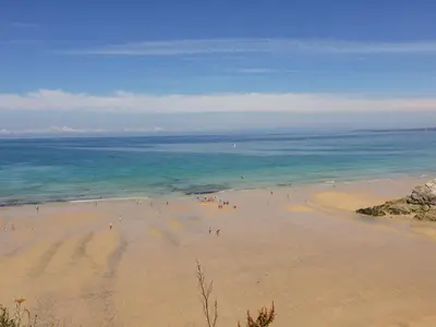 a group of people on a beach near the ocean at Catch the Wave in Newquay