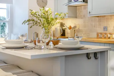 a kitchen with a table with plates and wine glasses at 2 Bed in Fowey oc-r30265 in Fowey