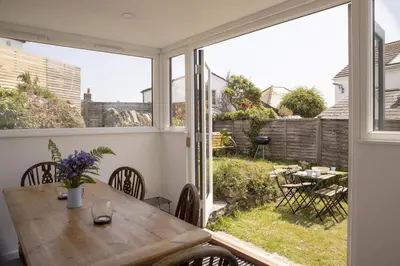 a dining room with a table and a large window at Gorgeous Cottage Parking Short Walk to Beach in Gorran Haven