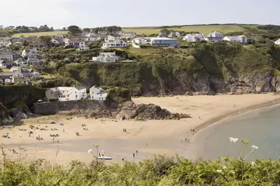 a group of people on a beach with houses at Gorgeous Cottage Parking Short Walk to Beach in Gorran Haven