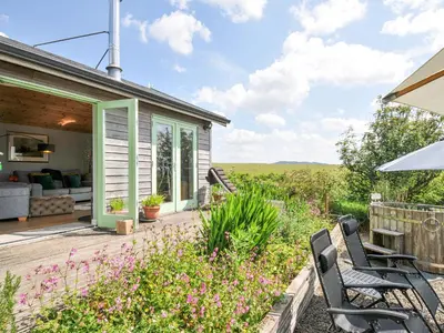 a patio with chairs and flowers in front of a house at Smugglers in Bodmin
