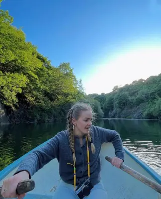 a young girl is rowing a boat on a river at Elderflower Hut in Port Isaac