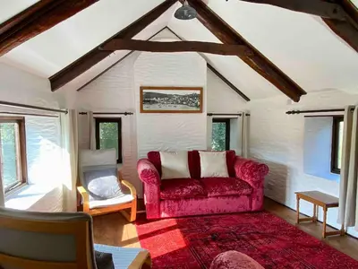 a living room with a red couch and a red rug at Cornish country house by the coast near Fowey in Lanteglos