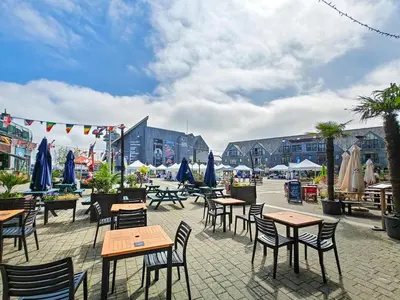 an outdoor patio with tables and chairs and umbrellas at 2 Bed in St. Gluvias oc-c29724 in Ponsanooth