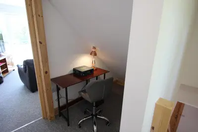 a desk with a lamp and a chair in a room at TwoPigalliie Heights in Nancekuke