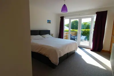 a bedroom with a bed and a large window at TwoPigalliie Heights in Nancekuke