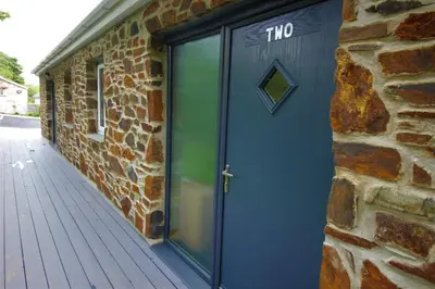 a blue door on the side of a brick building at TwoPigalliie Heights in Nancekuke