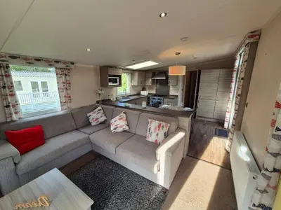 a living room with a couch and a kitchen at Swift in Saint Columb Road Station