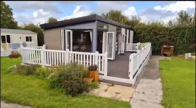 a tiny house with a porch and a white railing at Swift in Saint Columb Road Station