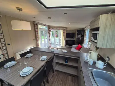 a kitchen and living room with a table and a sink at Swift in Saint Columb Road Station