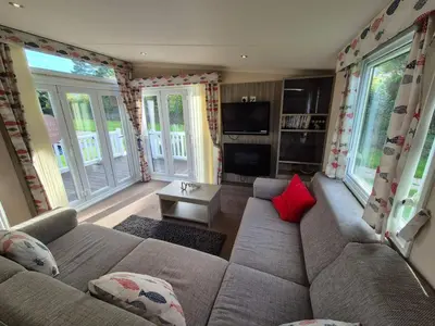 a living room with a brown couch and red pillows at Swift in Saint Columb Road Station