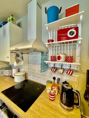 a kitchen with white cabinets and a black counter top at Apartment in Constantine in Constantine