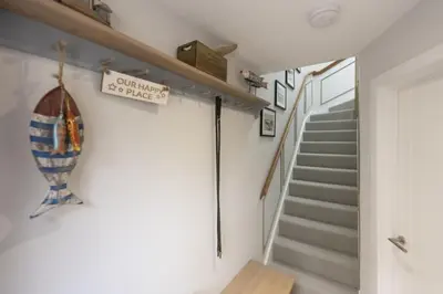 a staircase in a home with a stair case and a stair railing at Harlyn Folly, Apartment 6, Harlyn in St Merryn