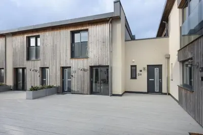 an exterior view of a building with black doors at Harlyn Folly, Apartment 6, Harlyn in St Merryn